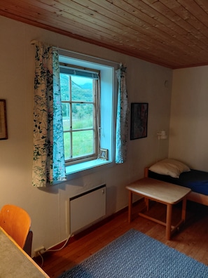 A room with a window, a bed, a table, and a chair. - Apartment in Stamsund (Stamsund)