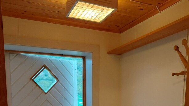 A room with a wooden door, a radiator, and a small window. - Apartment in Stamsund (Stamsund)