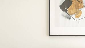 A neatly arranged bedroom with a bed, a bedside table with a lamp, and a framed picture on the wall. - Brand-New Premium Retreat|Pool &Gym| Parking|Train (Mitchelton)