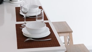 A modern dining area with a white table set for two, including plates, glasses, and cutlery. - The Valley Great Value| Sofa Bed |Parking|Pool&Gym (Fortitude Valley)