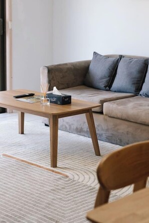 Ein Wohnzimmer mit einer Couch, einem Holztisch und einem Sessel.