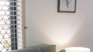 Ein Bett mit flauschigen Kissen, einer Nachttischlampe und einem Fenster mit Jalousien.