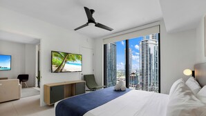 Ein modernes Hotelzimmer mit Bett, Schreibtisch, Stuhl, Fernseher und Blick auf die Stadt.