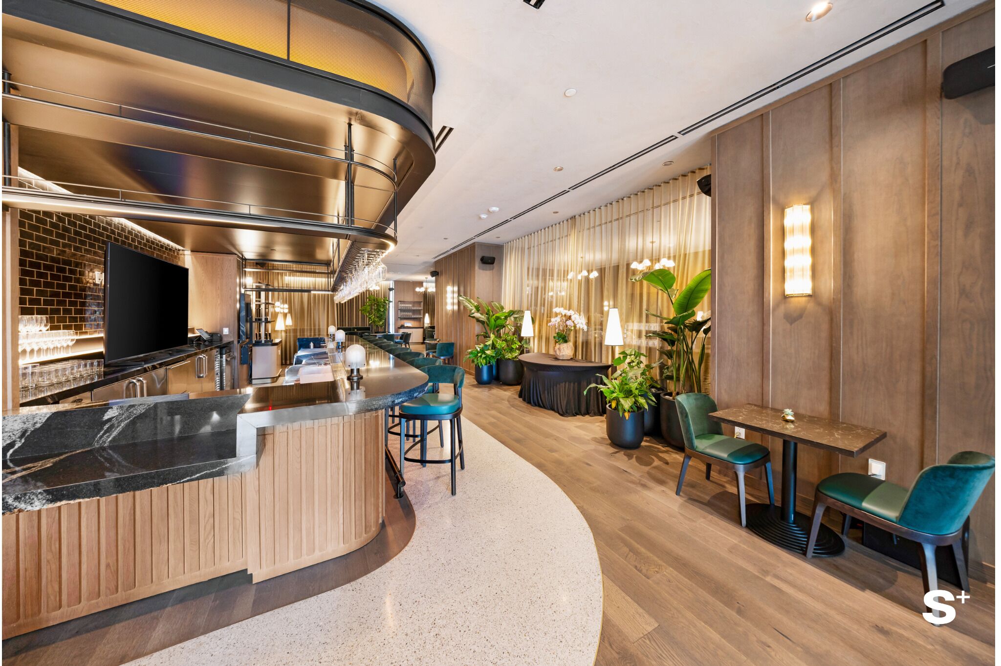 A modern interior with a curved bar, seating area, and potted plants.
