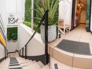 Eine Treppe mit Handlauf, einem Blumentopf und einem Schild mit dem Namen 'Mary Carmen'.