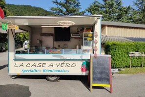 A food truck named 'LA CASE A VÉRO' with a signboard, a menu board, and a chalkboard.