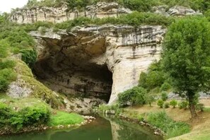 A natural rock formation with a river flowing through it.