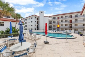 Un hôtel doté d’une piscine, de chaises longues et de parasols.
