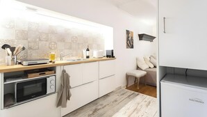 Una cucina moderna con pensili bianchi, un piano di lavoro in legno e un backsplash decorato.