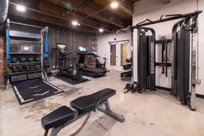 Een sportschool met loopbanden, krachtapparaten en fitnessballen.