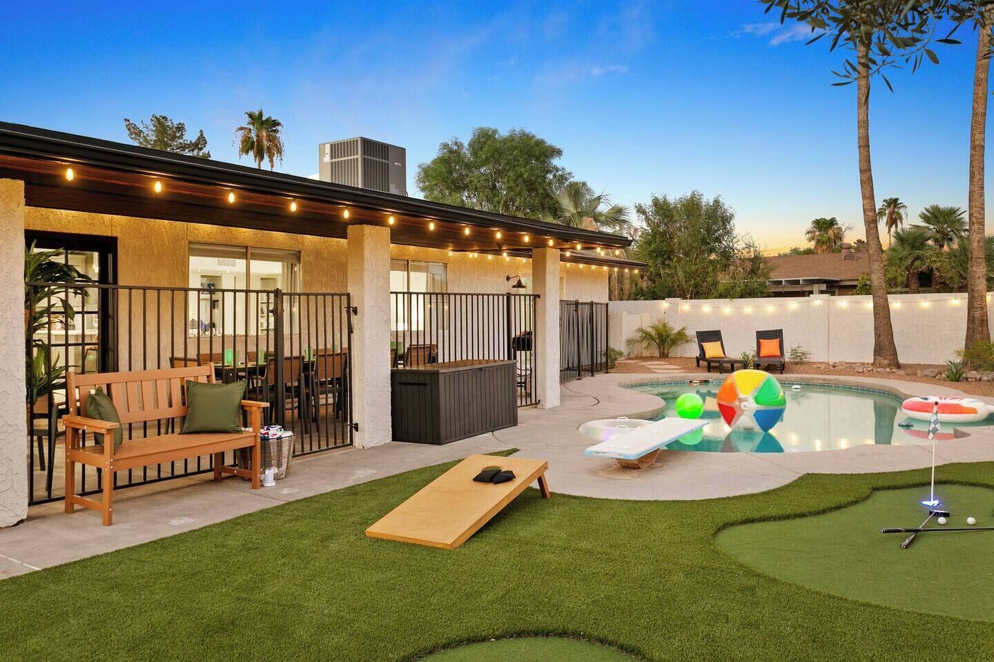 A backyard with a pool, a hot tub, a wooden deck, and a patio area.