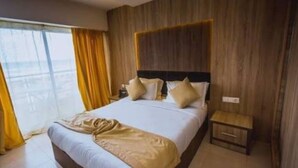 A hotel room with a bed, a nightstand, and a view through a window. - Hotel Mazafran (Algiers)