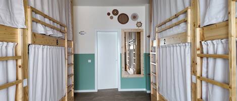 A corridor with bunk beds, a door, and wall decorations.