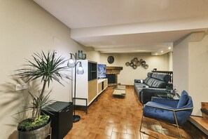 A living room with a sofa, a coffee table, a TV, and a plant.