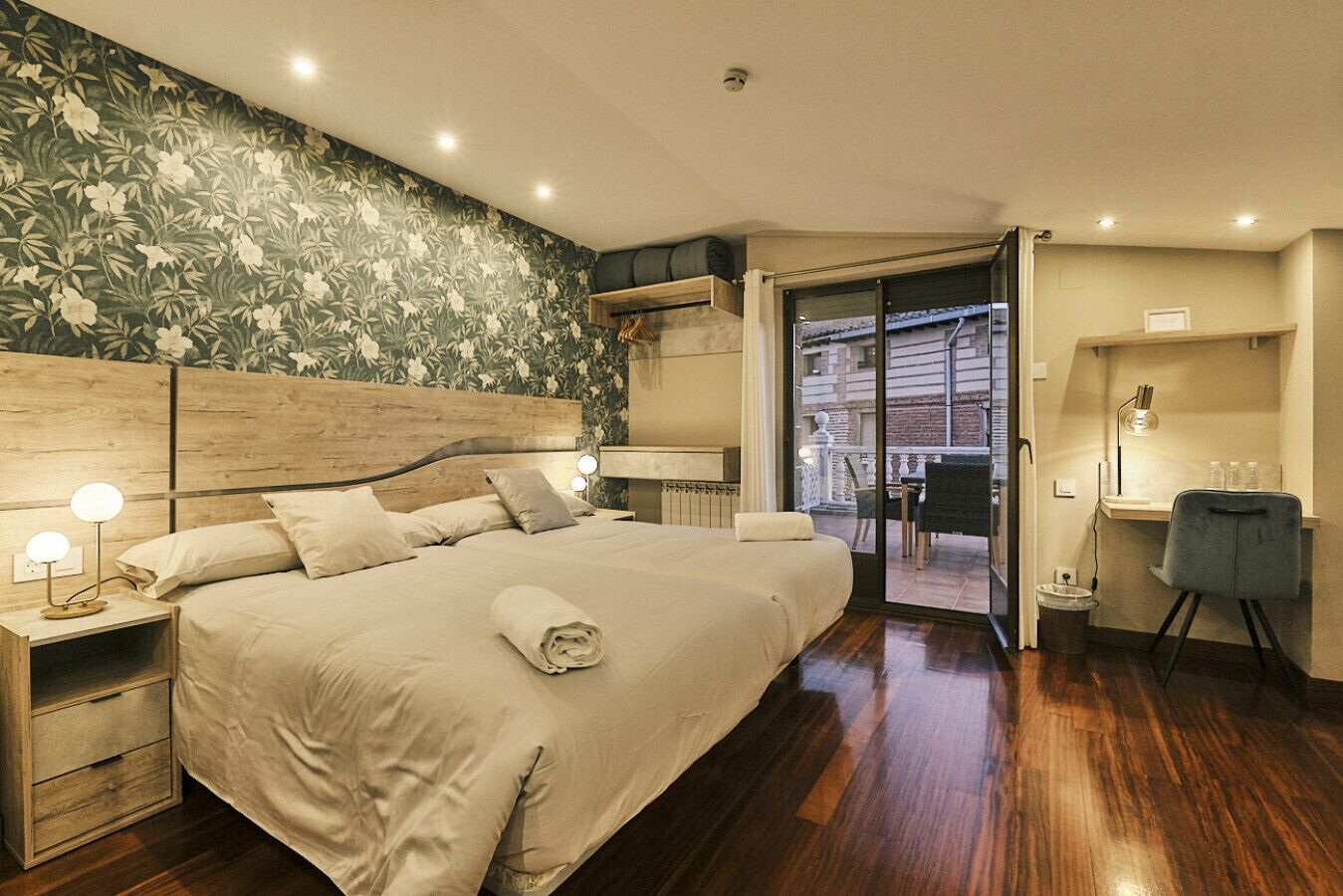A hotel room with a large bed, a desk, and a view of the city.