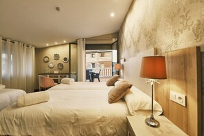 A hotel room with two beds, a desk, and a view of the city.