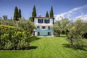 A two-story house with a swimming pool, surrounded by well-maintained gardens and tall trees. - Villa Art with Private Pool (San Felice del Benaco)