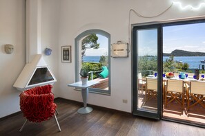 Ein Zimmer mit Meerblick, ein für das Essen gedeckter Tisch und ein roter Stuhl.