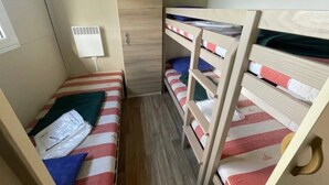 A small, compact room with bunk beds, a window, and a wall-mounted air conditioner. - Chalet 3 étoiles - Piscine  - ccbgahh (Chatel-Chéhéry)