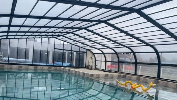 An indoor swimming pool with a glass ceiling and a yellow pool toy. - Chalet 3 étoiles - Piscine  - ccbgahh (Chatel-Chéhéry)