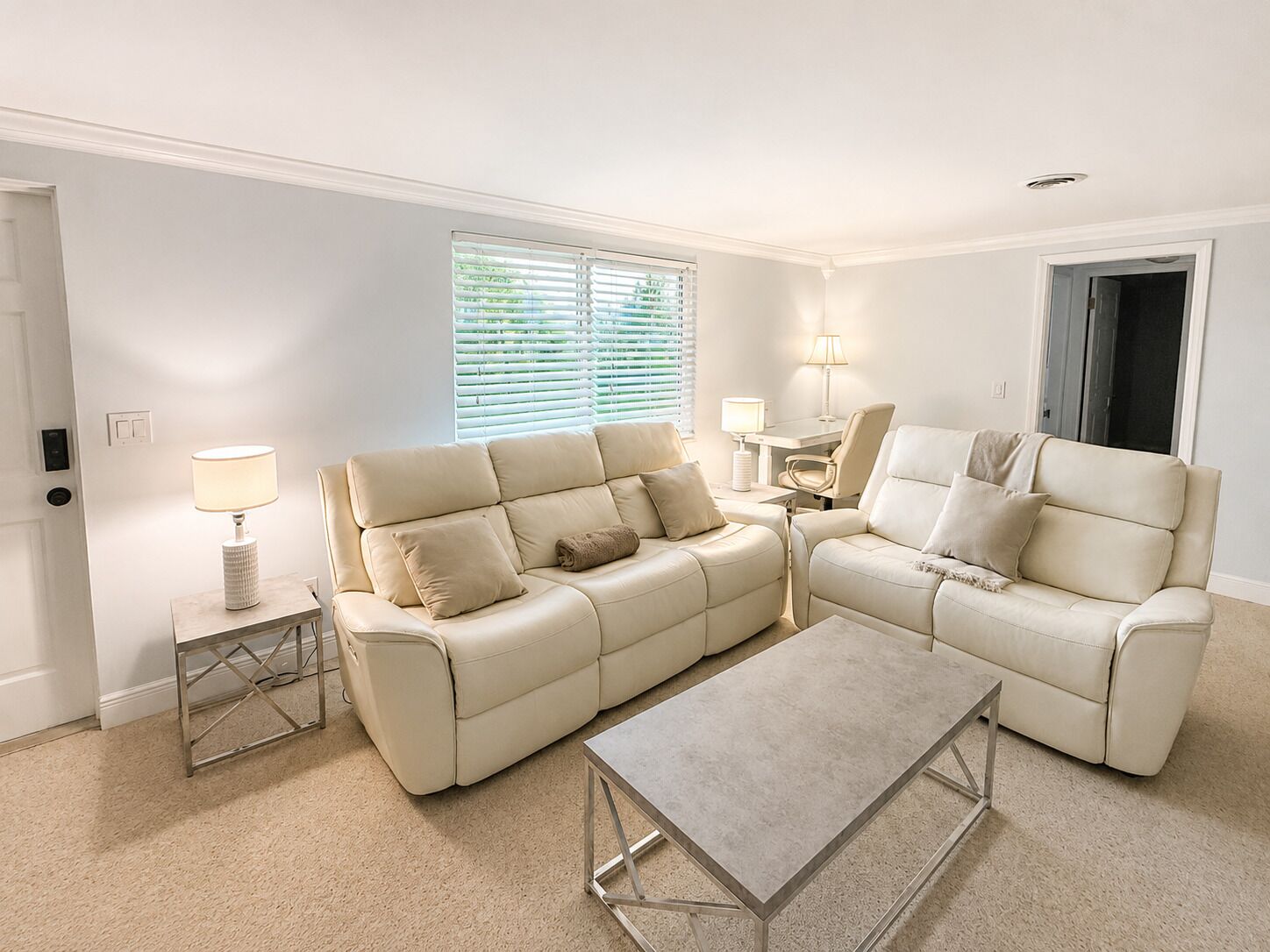 A living room with a beige sofa, a coffee table, and two lamps.