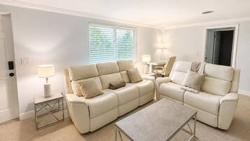 A living room with a beige sofa, a coffee table, and two lamps.