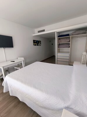 A bedroom with a bed, a desk, a TV, and a wardrobe. - Modern Apartment in Microcentro (Buenos Aires)