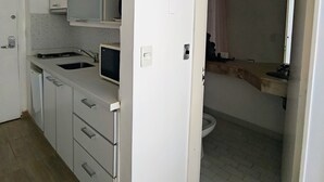 Eine moderne Küche mit weißen Schränken, einer eingebauten Mikrowelle und einem Spülbecken.