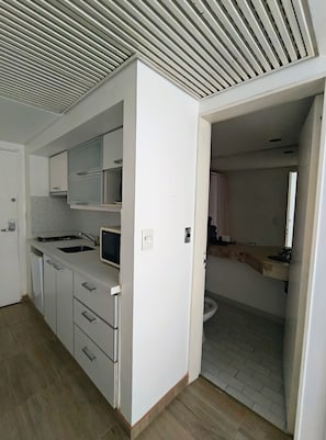 A modern kitchen with white cabinets, a built-in microwave, and a sink. - Modern Apartment in Microcentro (Buenos Aires)