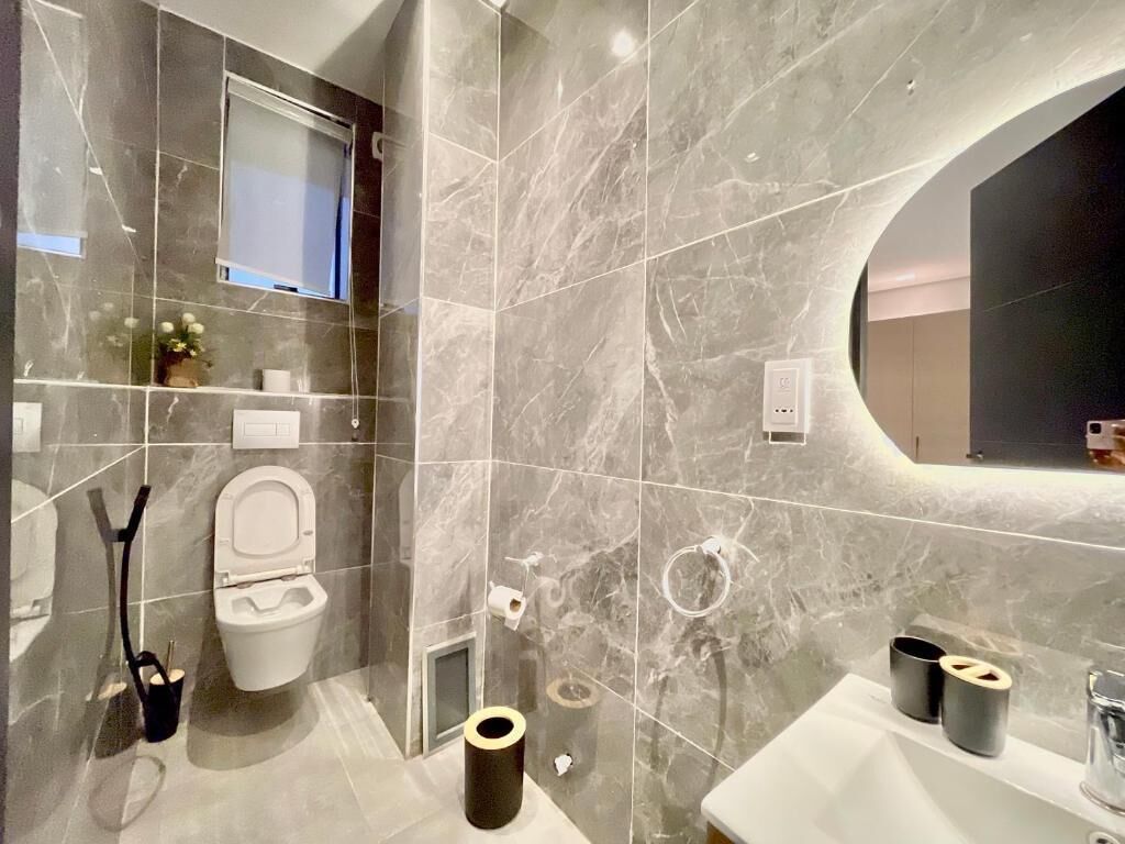 A modern bathroom with a toilet, bidet, and sink.