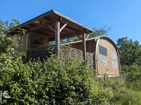 A wooden structure with a covered porch and a large window.
