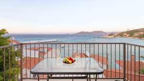 A balcony with a table set for two, overlooking a coastal view with a clear sky. - Studio Tepes - Natassa Samos Seaview Balcony Suite (Samos)