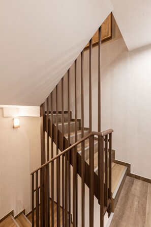 Eine Holztreppe mit Geländer und einer Wandleuchte.