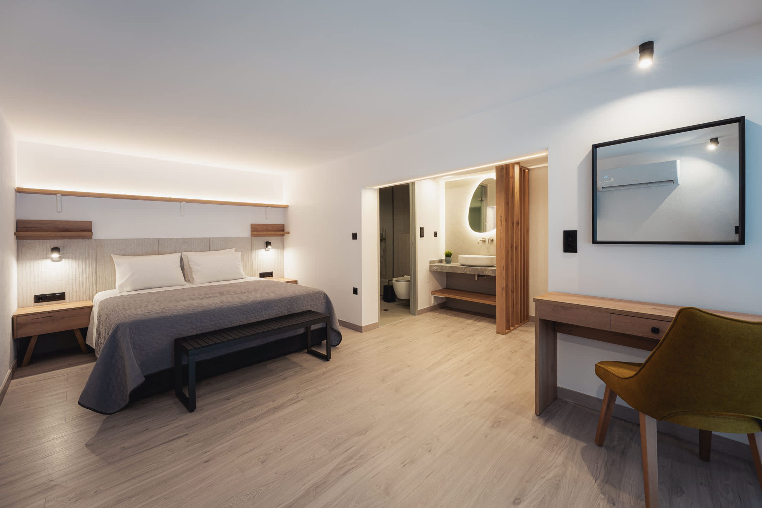 Ein modernes Schlafzimmer mit einem Bett, Nachttischen, einem Schreibtisch und einem Stuhl.