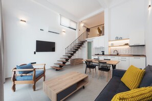 A modern living space with a staircase, a dining area, and a kitchen. - Chalkidiki Peaceful Retreat With Private Parking (Sithonia)