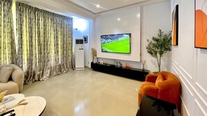 Una sala de estar moderna con una televisión de pantalla plana, un sofá y una mesa de centro.
