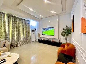 A modern living room with a flat-screen TV, a sofa, and a coffee table.