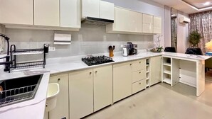 Uma cozinha moderna com armários brancos, fogão embutido e bancada.