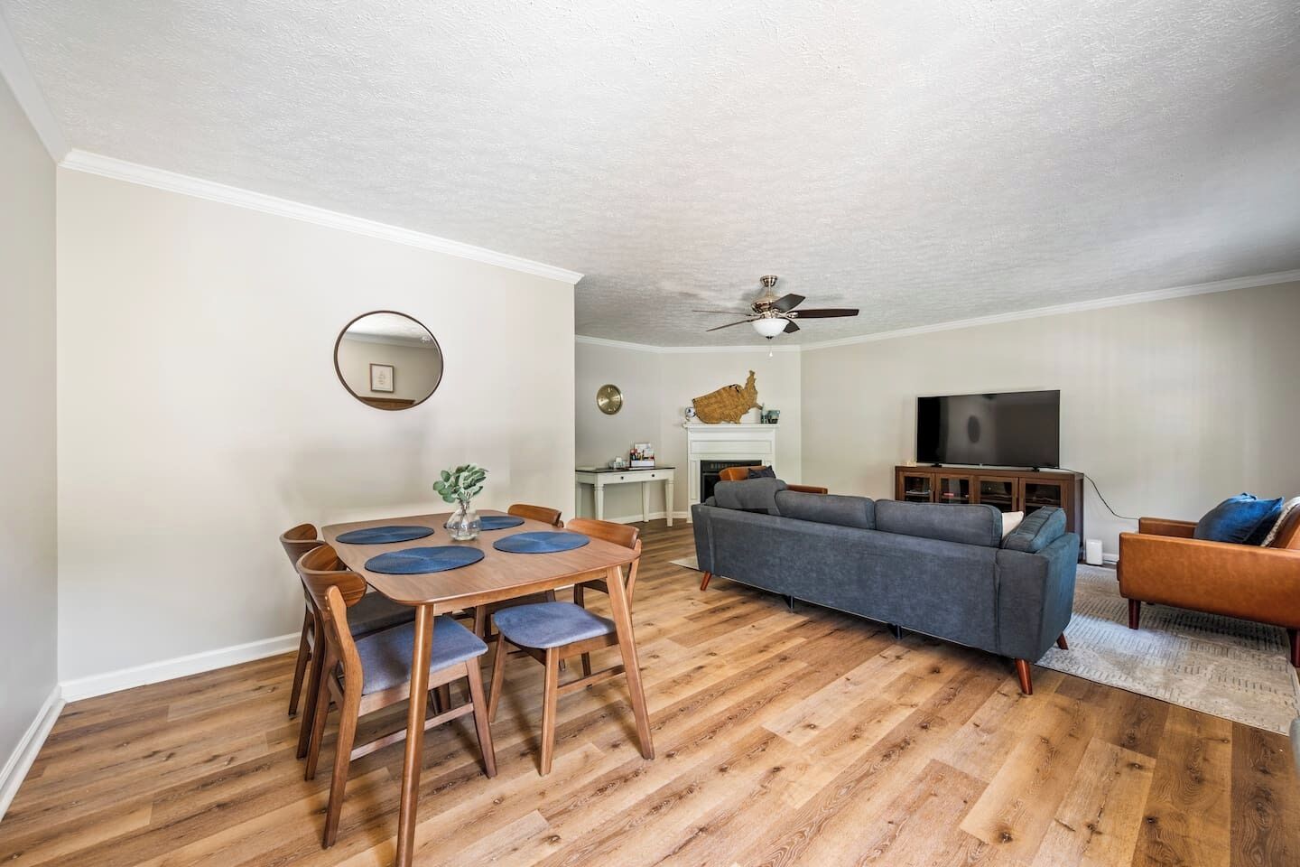 Un salon comprenant un canapé, un téléviseur et un coin repas avec une table et des chaises.