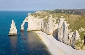 A coastal landscape with white cliffs and a clear blue sea.