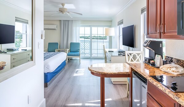 Ein Hotelzimmer mit Bett, Schreibtisch, Kaffeemaschine und Blick ins Freie.