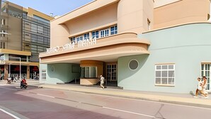 Un edificio moderno con fachada curva, amplias ventanas y una entrada destacada.