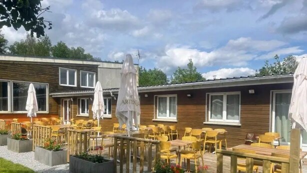 A patio area with outdoor seating and umbrellas, surrounded by wooden deck and planters. - Chalet - Piscine  - ccbgdbd (Signy-le-Petit)