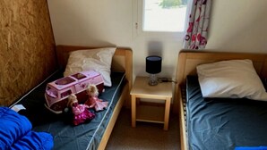 A room with two single beds, a small table with a lamp, and a window with curtains. - Chalet - Piscine  - ccbgdbd (Signy-le-Petit)