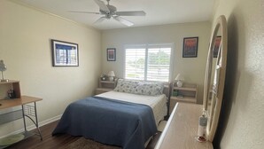 A bedroom with a bed, a desk, a chair, a ceiling fan, and a window with blinds. - Spacious 3 bed, 2 bth condo,  great space, in unit laundry and one car garage (Naples)