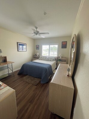 A bedroom with a bed, a desk, a chair, a ceiling fan, and a window with blinds. - Spacious 3 bed, 2 bth condo,  great space, in unit laundry and one car garage (Naples)