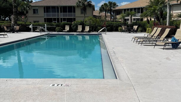 A swimming pool with lounge chairs and a building in the background. - Spacious 3 bed, 2 bth condo,  great space, in unit laundry and one car garage (Naples)