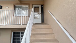 A staircase leading to an apartment entrance with a door marked '12'. - Spacious 3 bed, 2 bth condo,  great space, in unit laundry and one car garage (Naples)