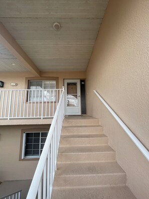 A staircase leading to an apartment entrance with a door marked '12'. - Spacious 3 bed, 2 bth condo,  great space, in unit laundry and one car garage (Naples)