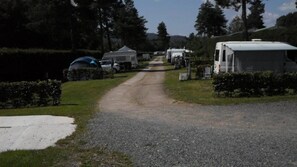 En grusgång som leder till husbilar och tält på en campingplats.